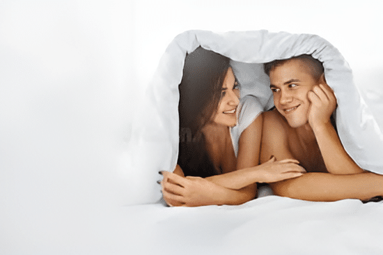 a man and women under sheets